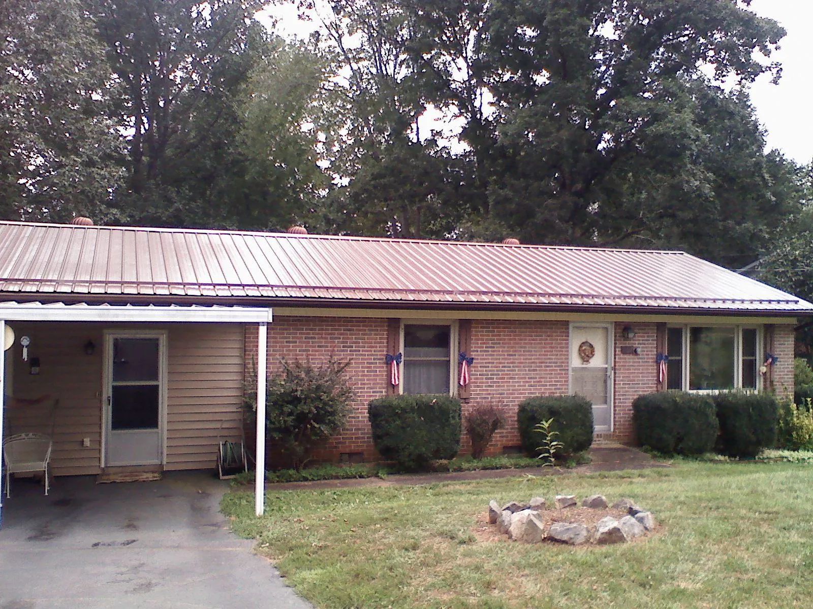 Bronze metal roof and carport on a brick ranch home — Roof Repair work by our crew in Dravosburg